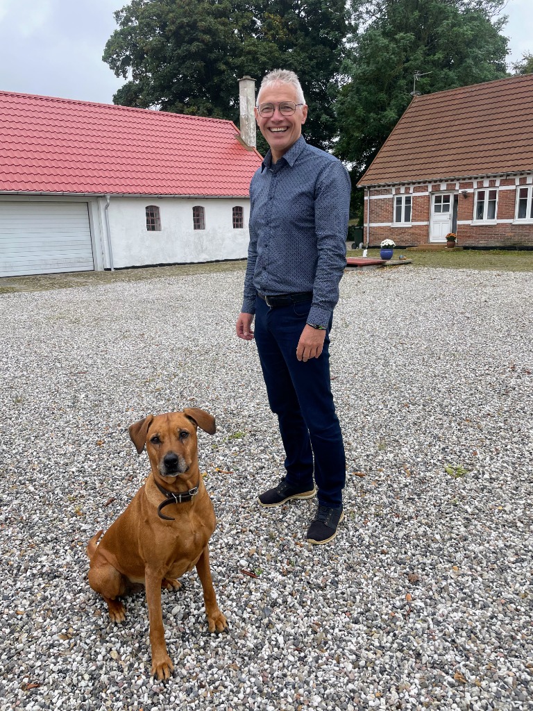 Ole Sørensen og hans Rhodesian Ridgeback Ella på gårdspladsens grus på Marupgaard