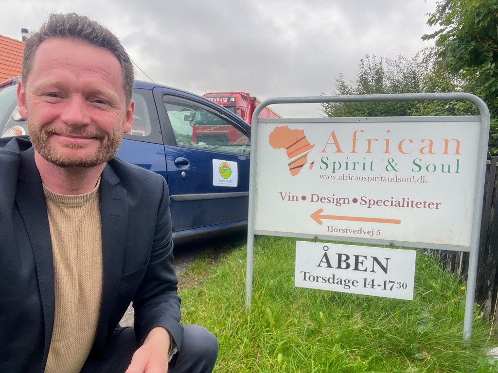 Jacob Lænsø i selfie foran African Spirit & Soul skiltet med Tour Djurs-bilen i baggrunden