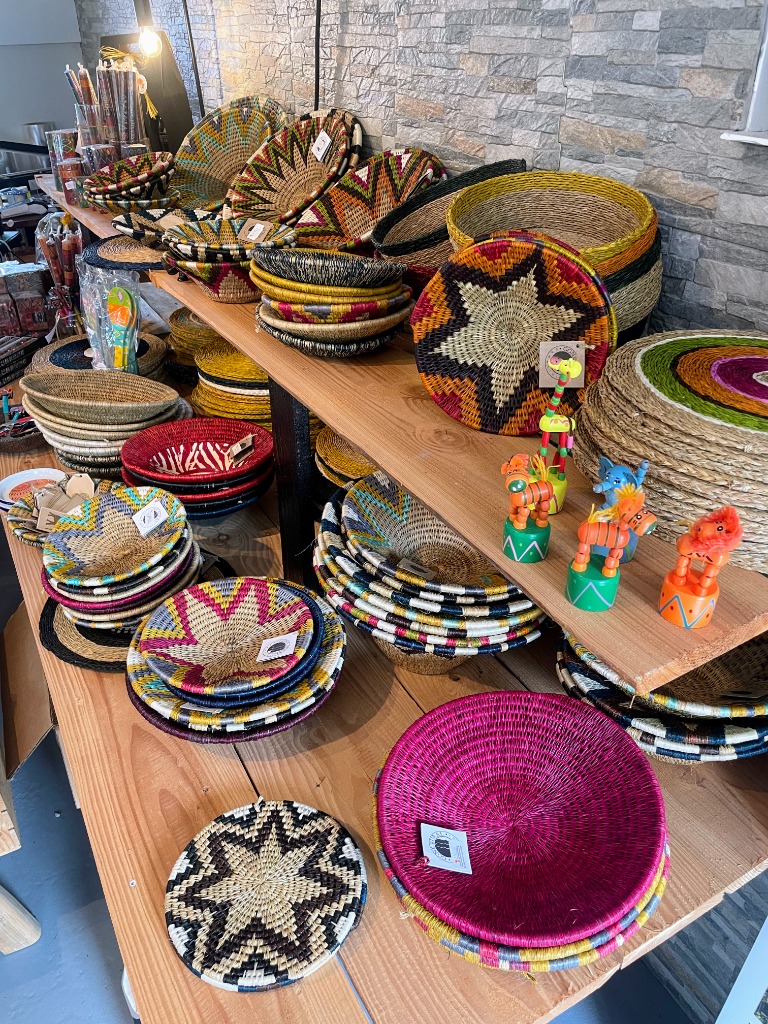 Håndflettede afrikanske kurve, skåle og bakker i farvestrålende mønstre på træhylder i butikken