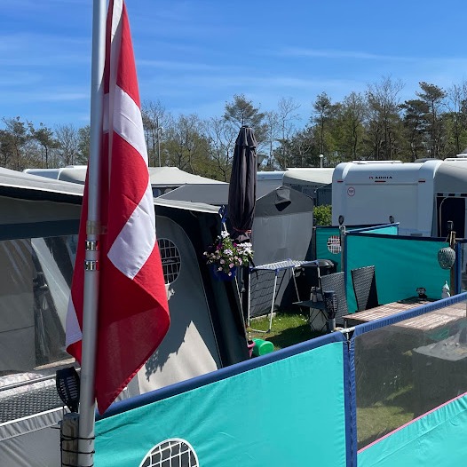 Dannebrog vajer mellem campingvogne og læhegn