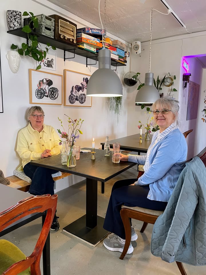 To glade gæster nyder kaffe og kage i caféen hos Ellens Have