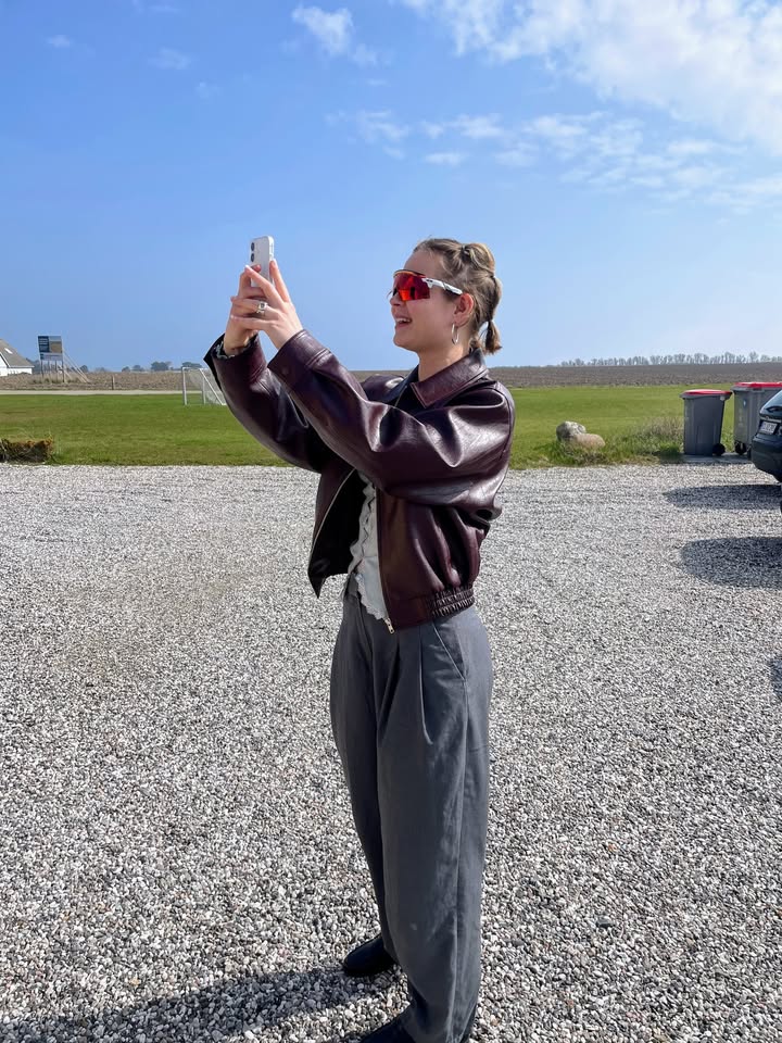 Anna Riis Lund tager foto i forårssolen med solbriller ved Dråby Strandvej