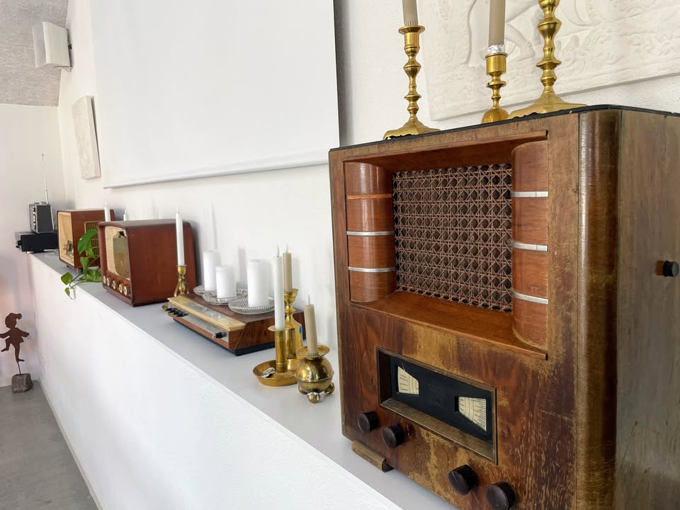 Klassiske vintage radioer og messingstager på hylden