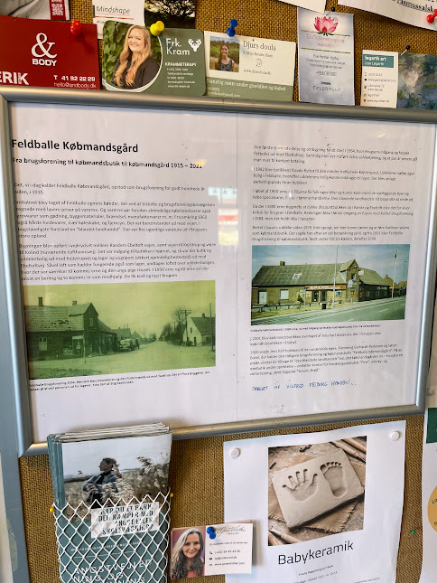 Opslagstavle med Feldballe Købmandsgårds historie fra 1915 til 2021