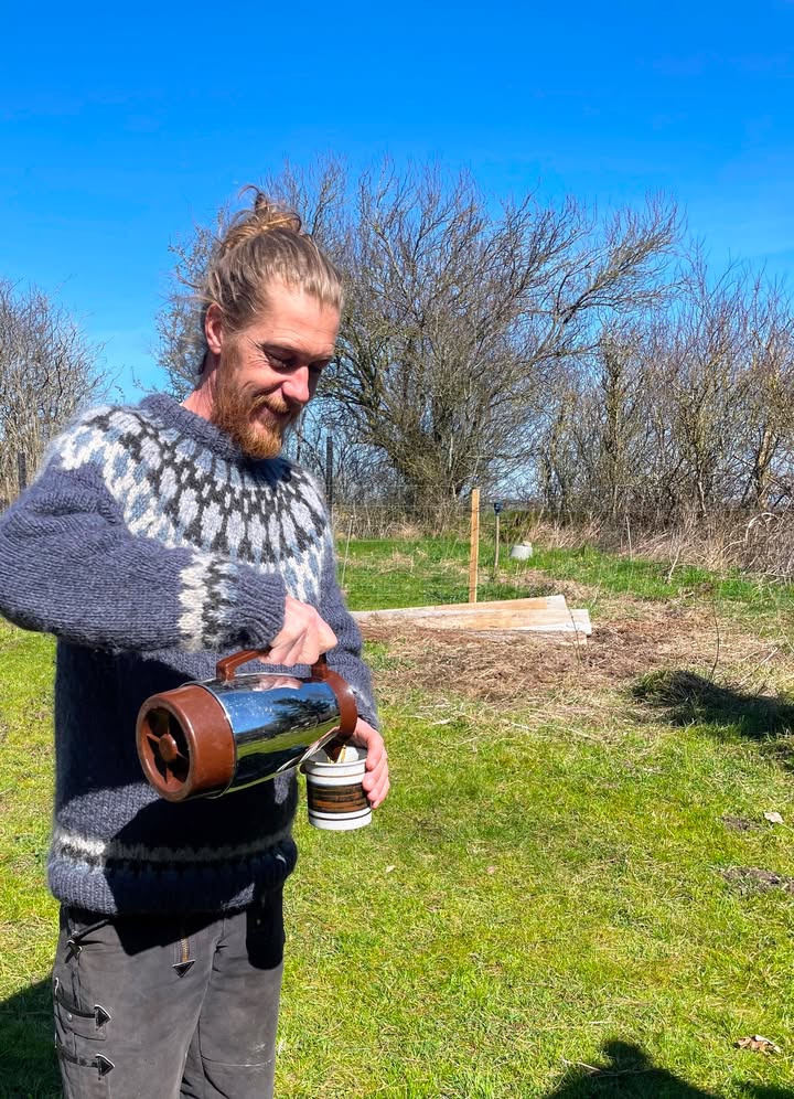 Christoffer skænker varm kaffe i haven